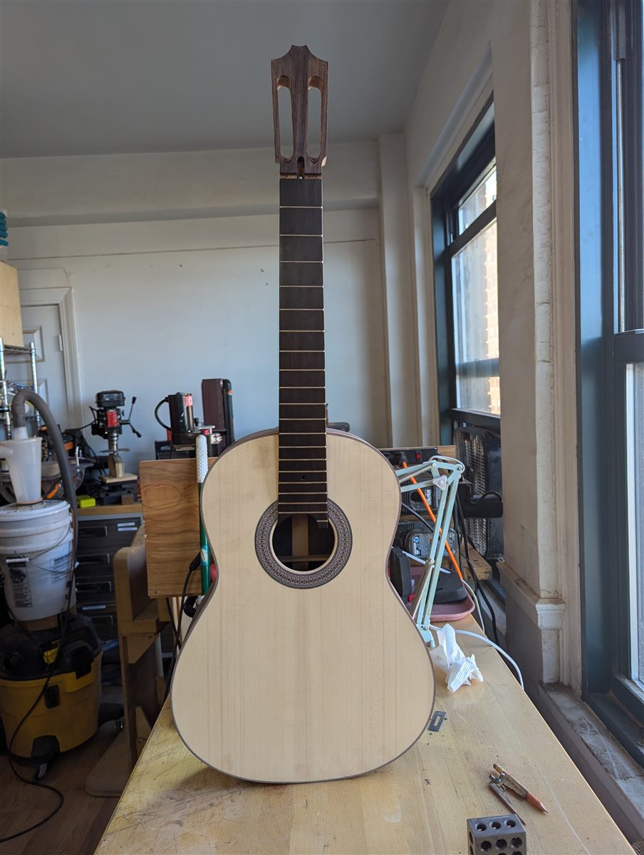 Full-body front view of the handbuilt classical guitar, headstock forward.
