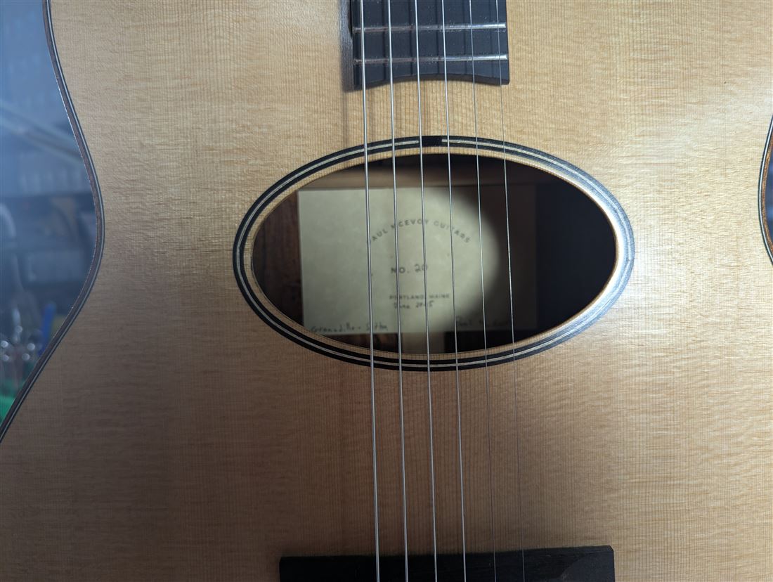 Interior shop label reading Paul McEvoy Guitars No. 20, Portland, Maine, visible through the soundhole.