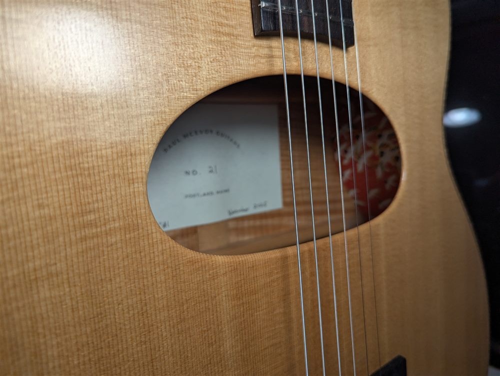 Interior shop label reading Paul McEvoy Guitars No. 21, Portland, Maine, visible through the soundhole of Jimmy.