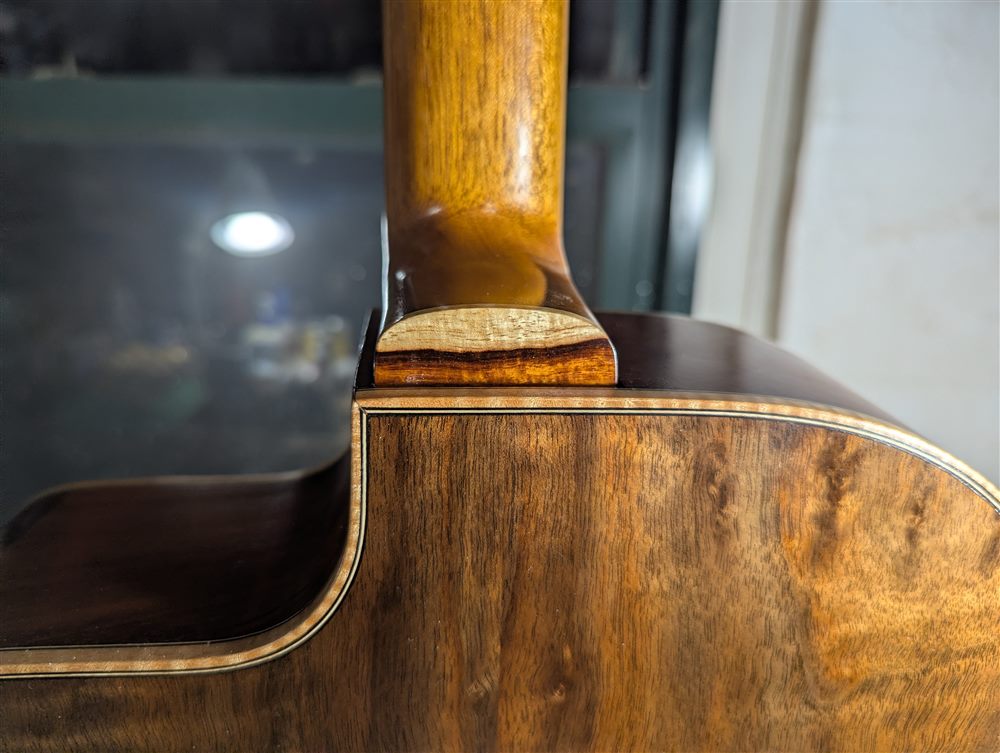 Close-up of the neck heel joinery on a handbuilt walnut and mahogany guitar by Paul McEvoy Guitars.