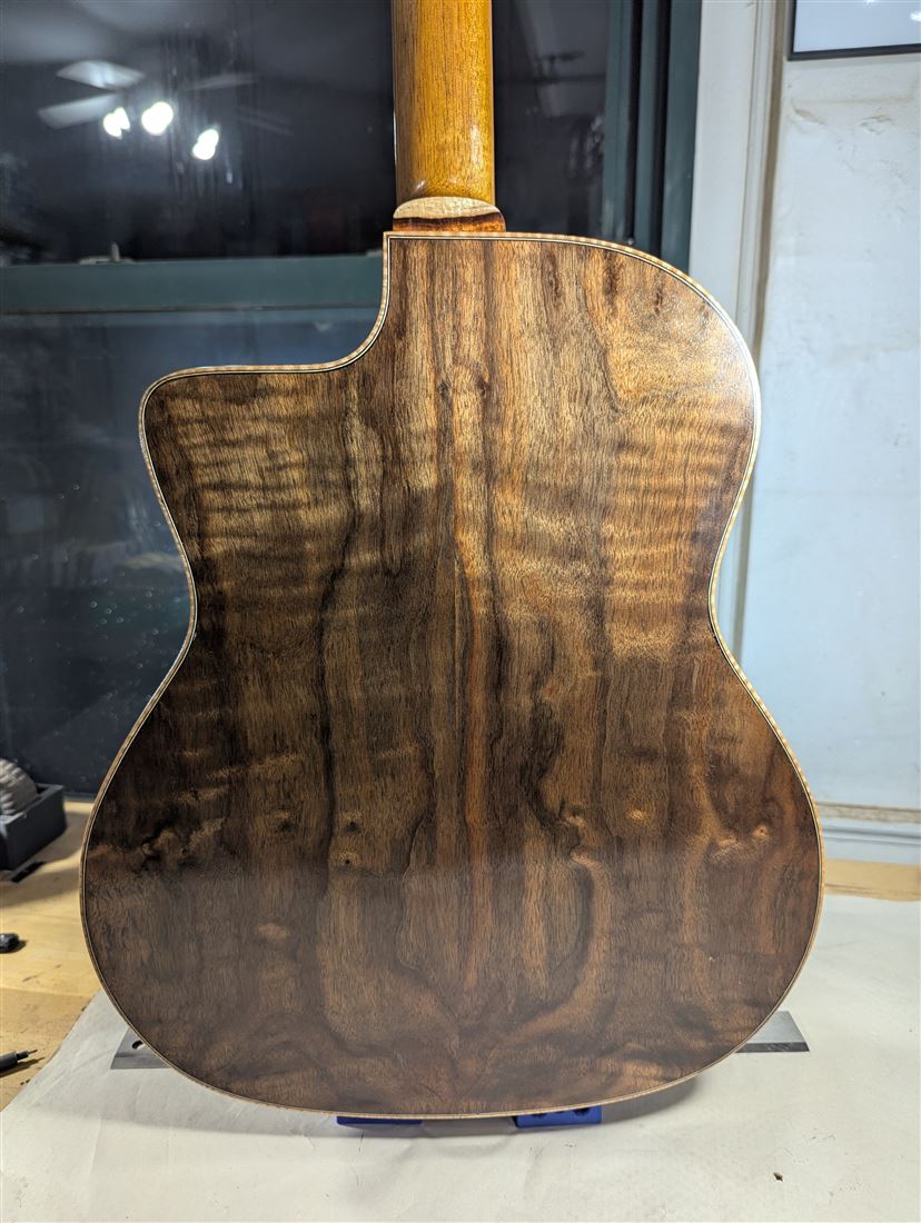 Full back view of the Ted Walnut Mahogany guitar showing rich figured walnut grain.
