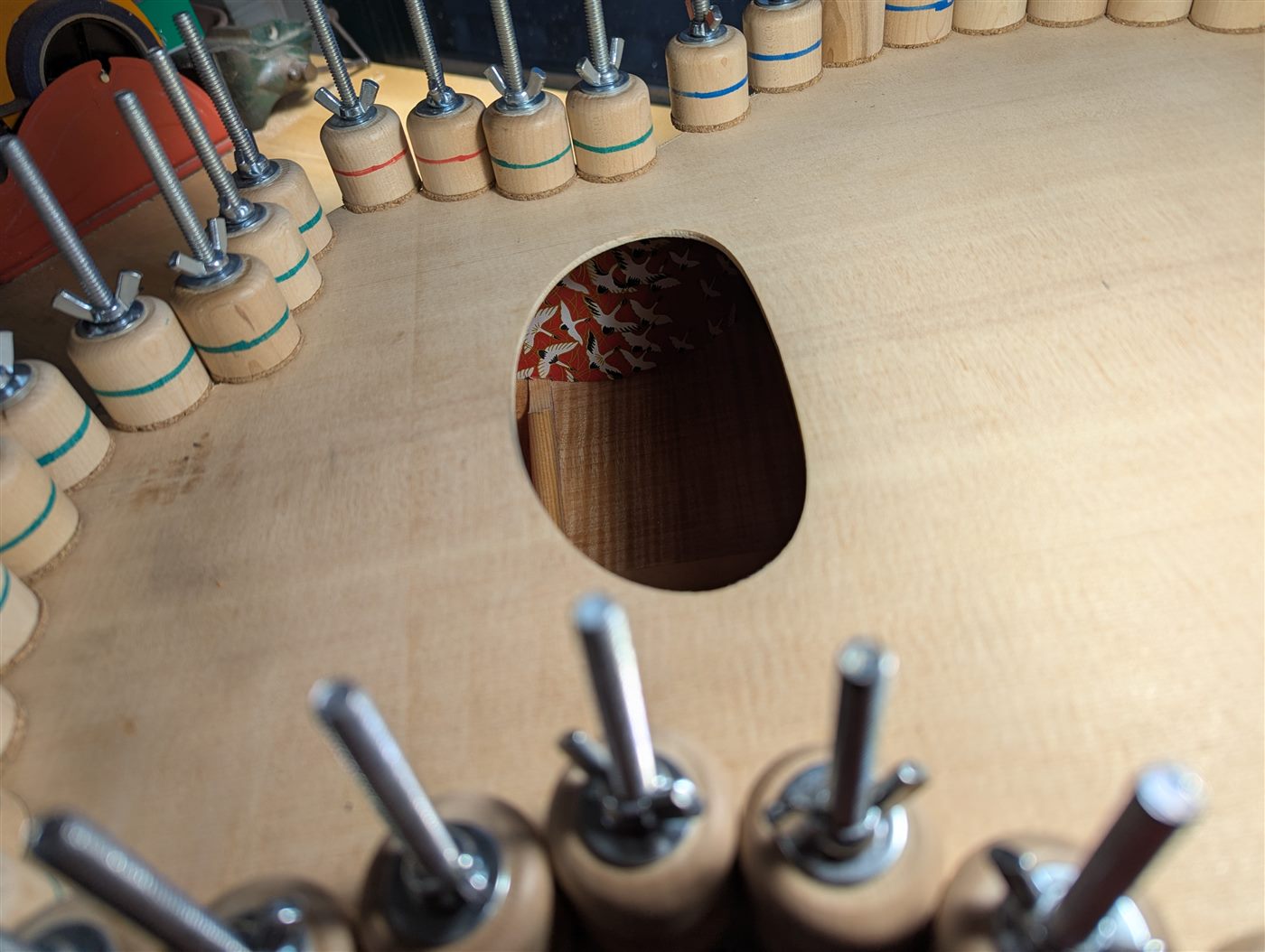 Gluing on a guitar back with a glimpse of Japanese paper visible inside.