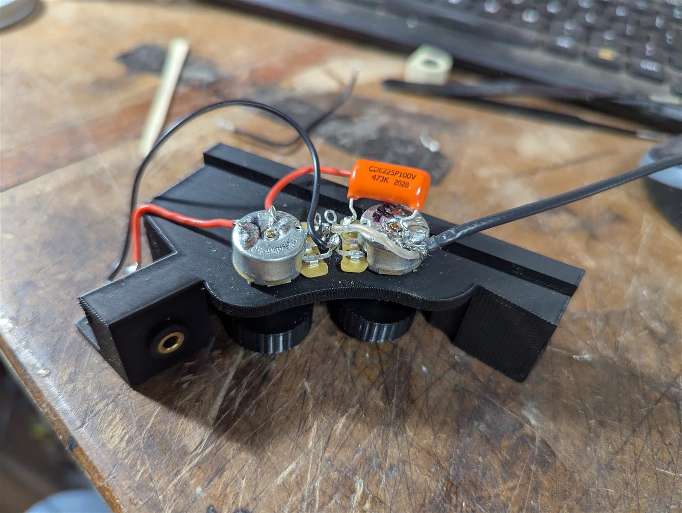 A 3d printed wiring harness for an acoustic guitar.