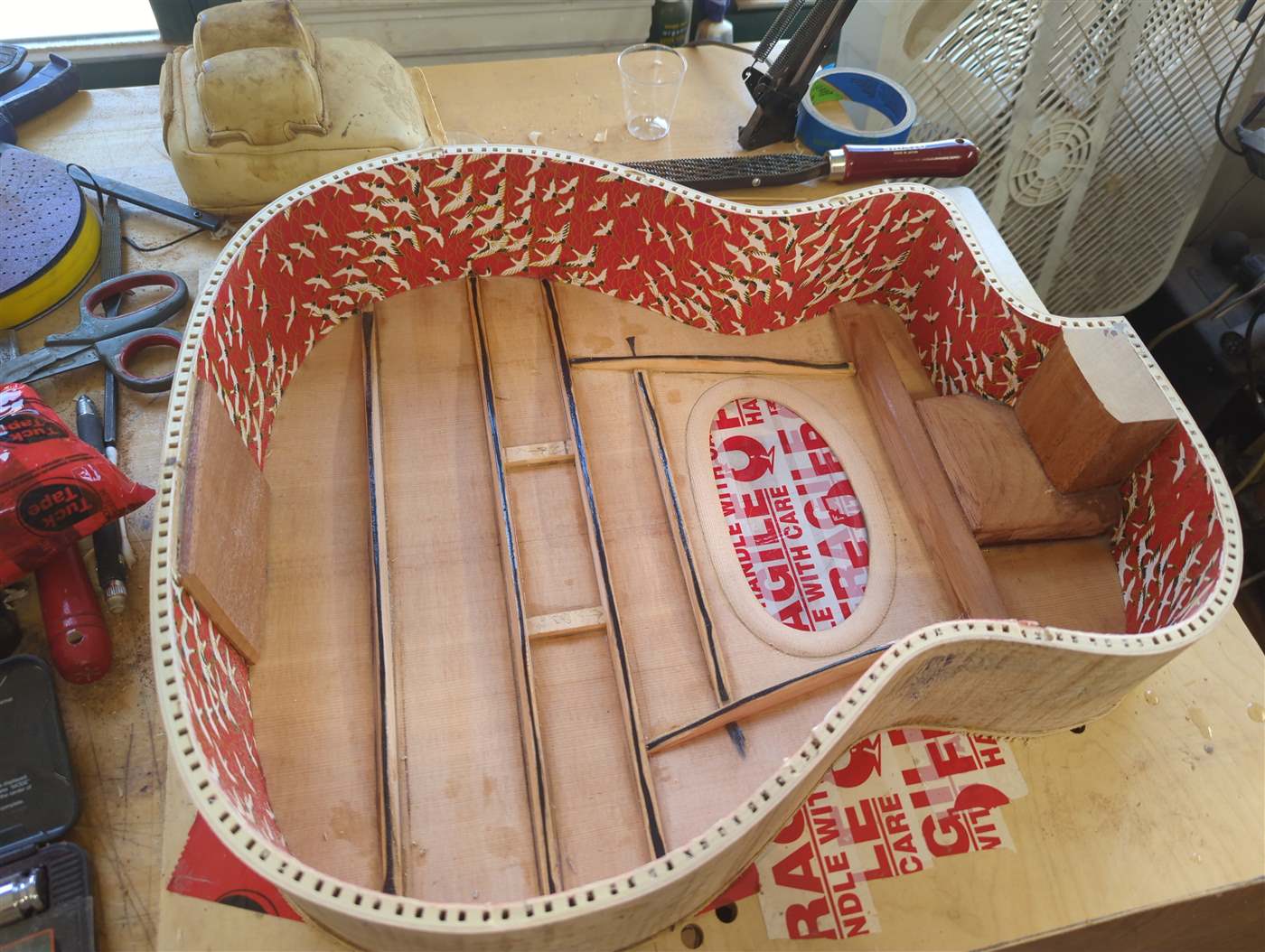 A Selmer style guitar with carbon fiber bracing reinforcement.