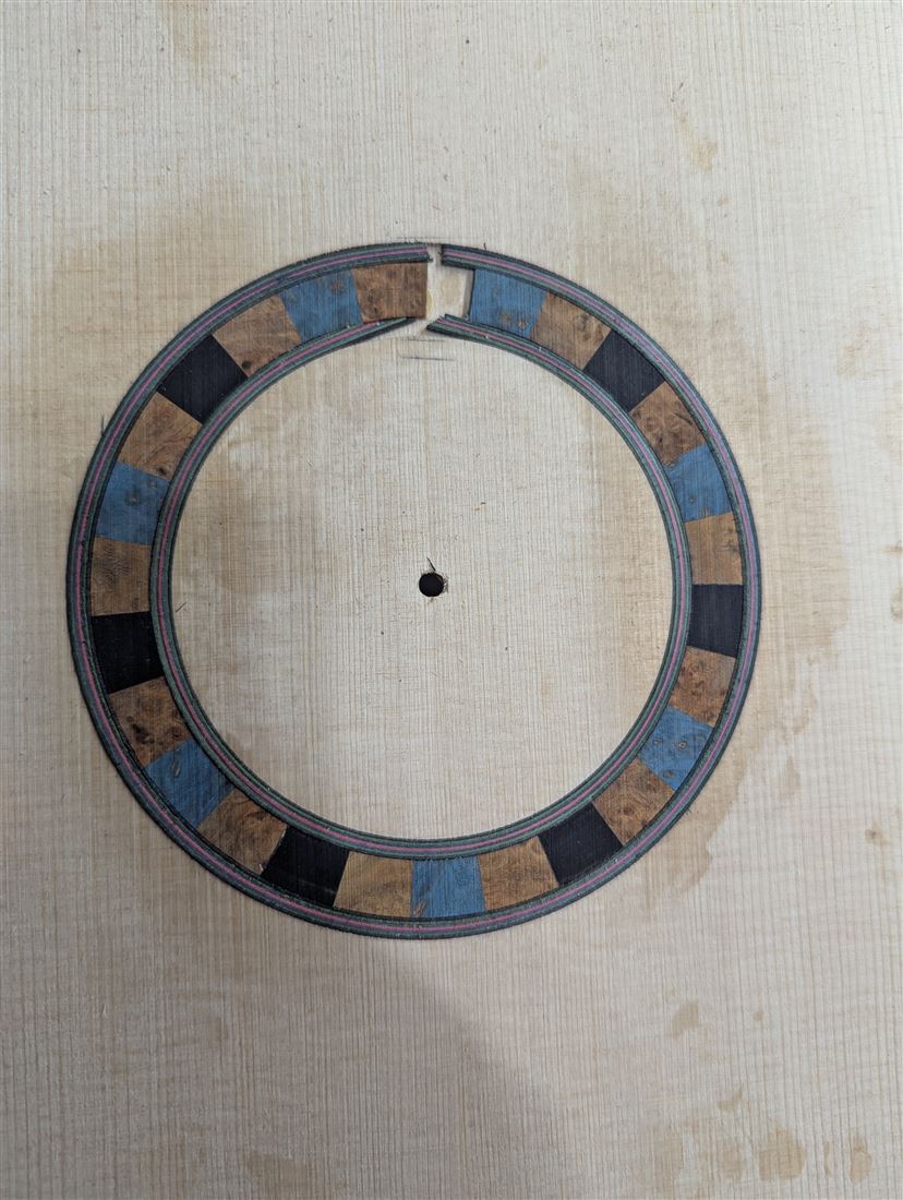 A mosaic rosette glued into a guitar top.